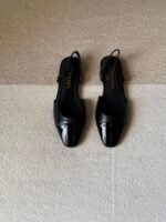 Chanel slingback shoes crafted "black leather with black patent cap toe"